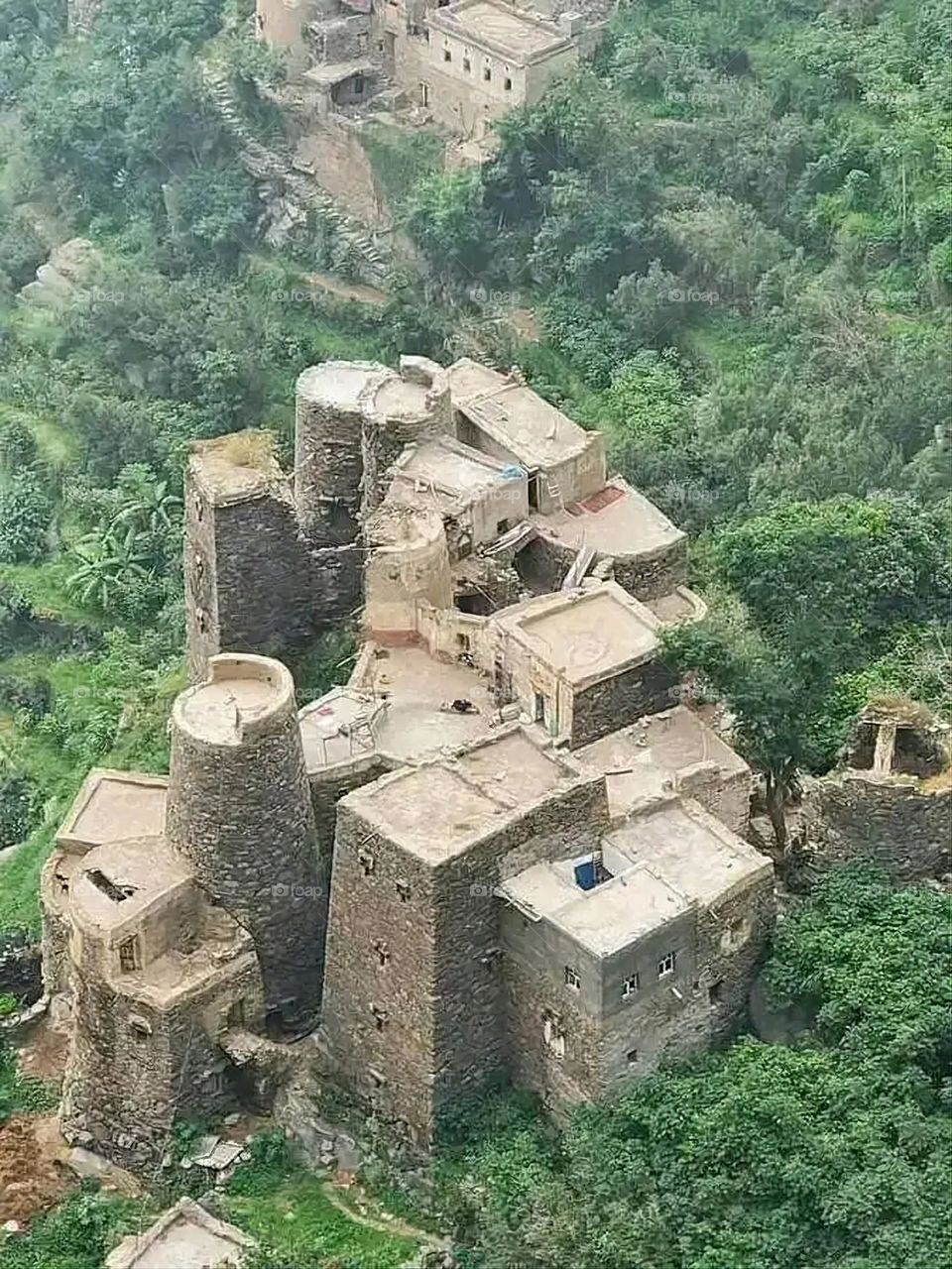 The image embodies a natural natural plate of the mountains of nature, where green agricultural stands are graded on the slopes as if they were lines of a poem, which fog harmoniously wrapped, and clouds hugged them in the mountain knife and the whis