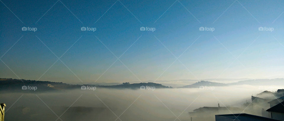 View of mountain against sky on foggy