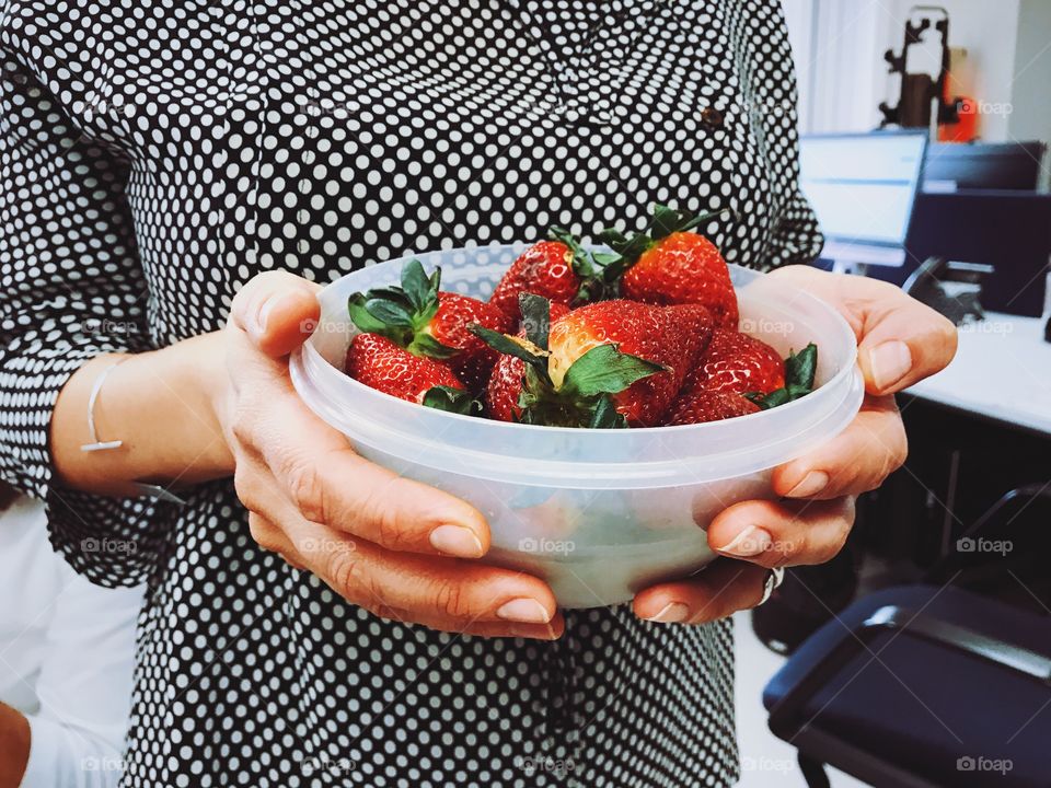 Woman holding bowl with strawberries