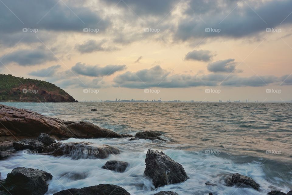 Rock beach in morning sunrise and cloudy day.