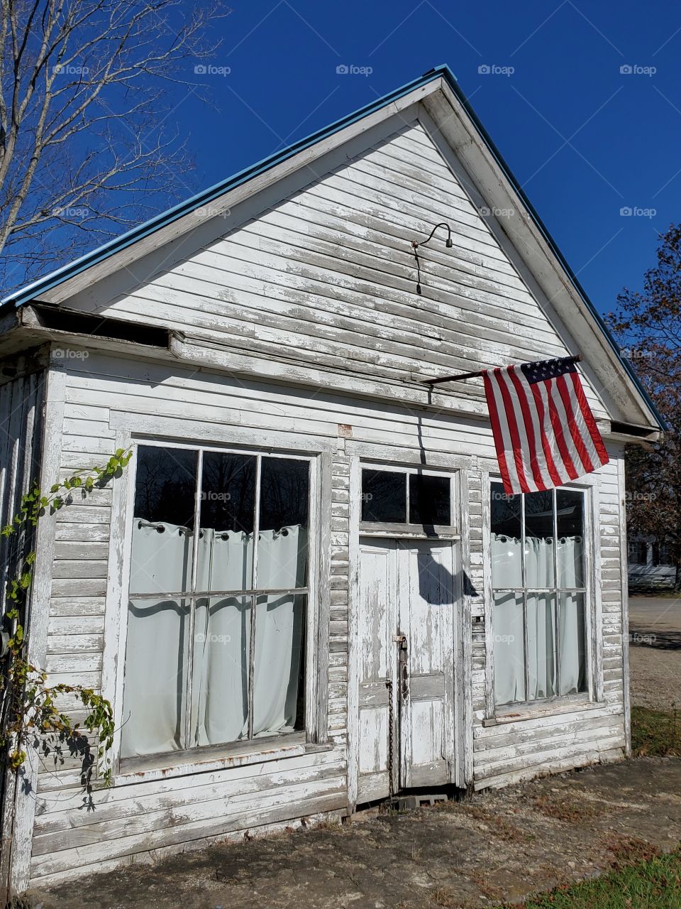 old, weathered storefront with American flag