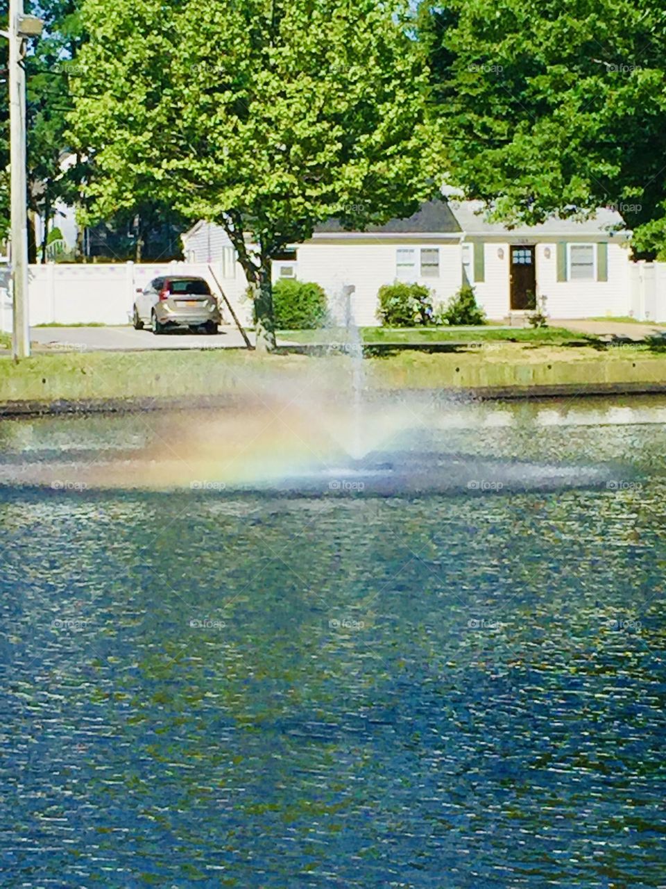 partial rainbow formed at a pond