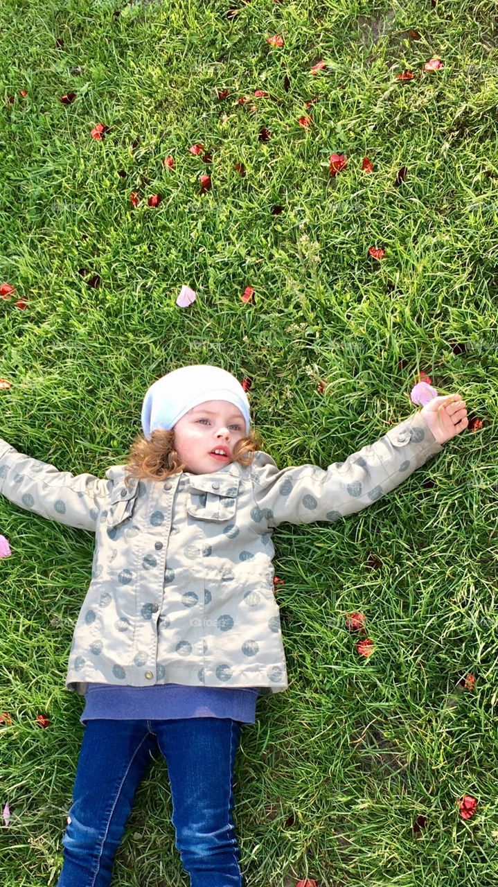 Funny cute girl lying on the grass 