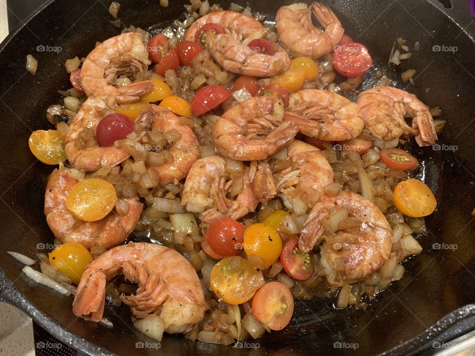 Pink Shrimp cooked in olive oil with sweet onion, garlic and fresh picked cherry tomatoes from the garden.