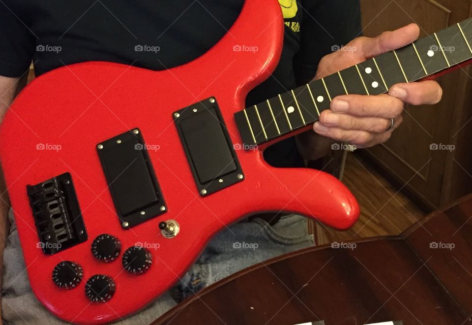Red electric guitar made by husband.