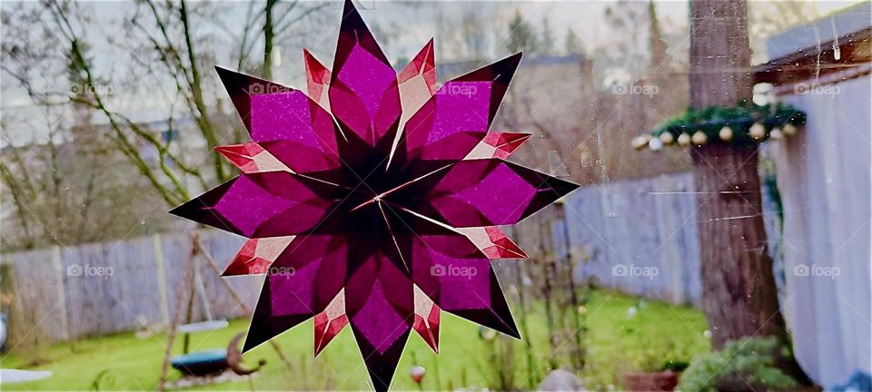 What a beautiful Christmas decoration it is, this artfully folded flower or star taped to a window of the beautiful house in “Bavaria”, Germany during the festive season. Hallelujah !!! 2023. Hypnotic Productions