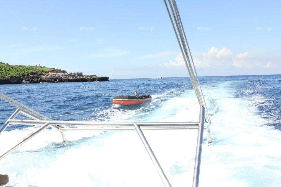 Boat pulls a rubber raft behind