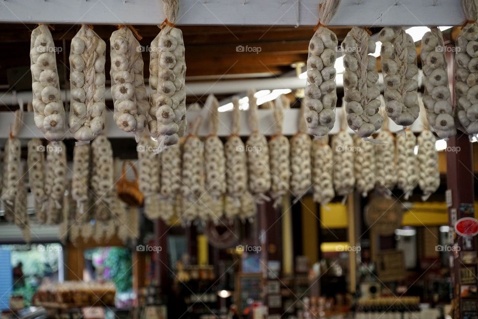 Garlic Cloves Hanging On Display In A Market