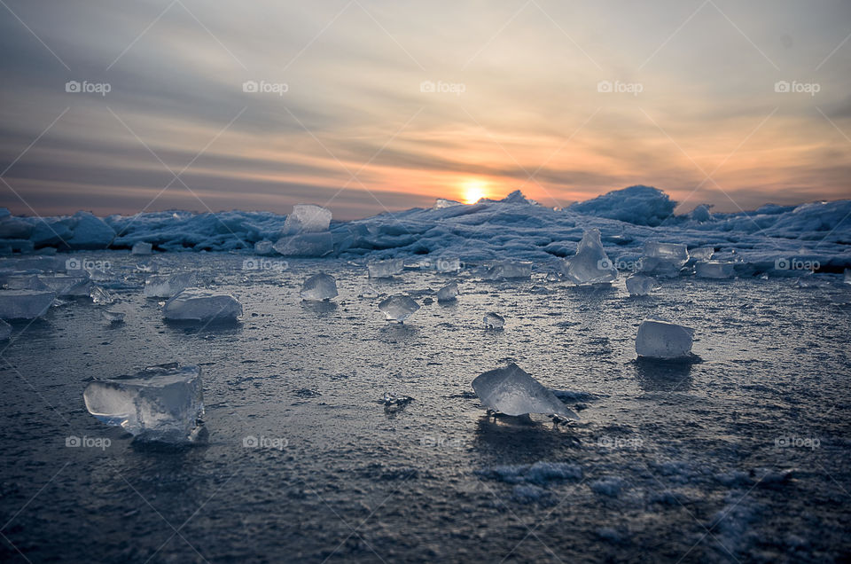 frozen winter sunrise sescape with ice and colorful sky