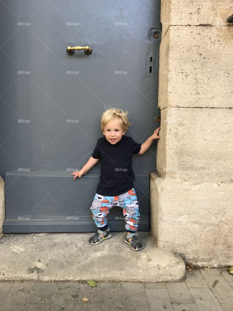 Baby toddler standing towards a blue wall