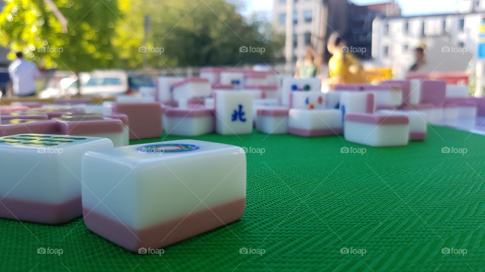 White and pink mahjong tiles on a green table