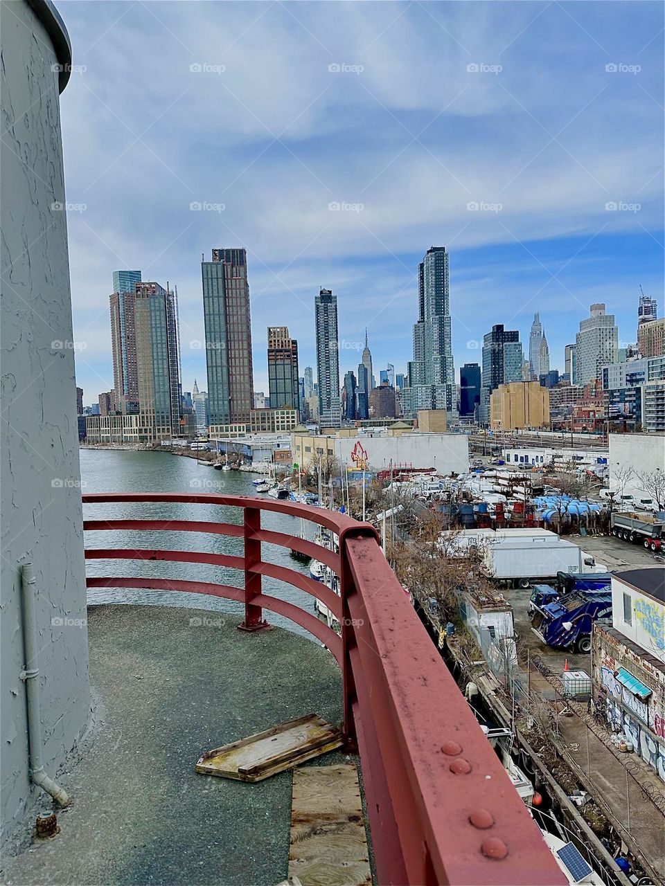 This is “Newtown Creek” seen from the “Pulaski Bridge” that connects “Greenpoint”, Brooklyn to LIC, Queens. In the distance we see “Manhattan” including the “Empire State Building”. 2024. Hypnotic Productions