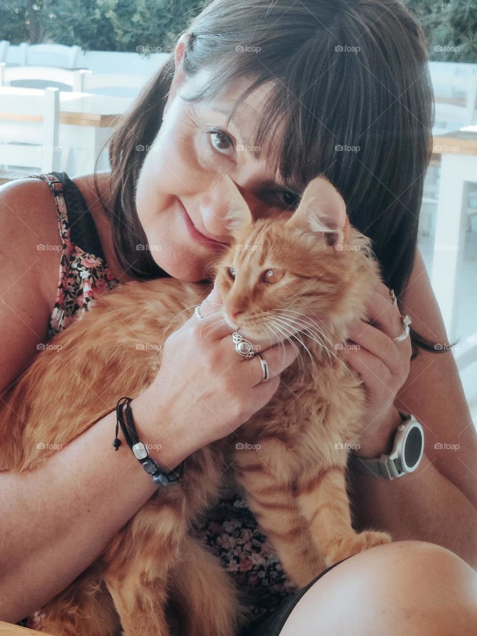 lady cuddling ginger cat in greece. looking at camera. cute