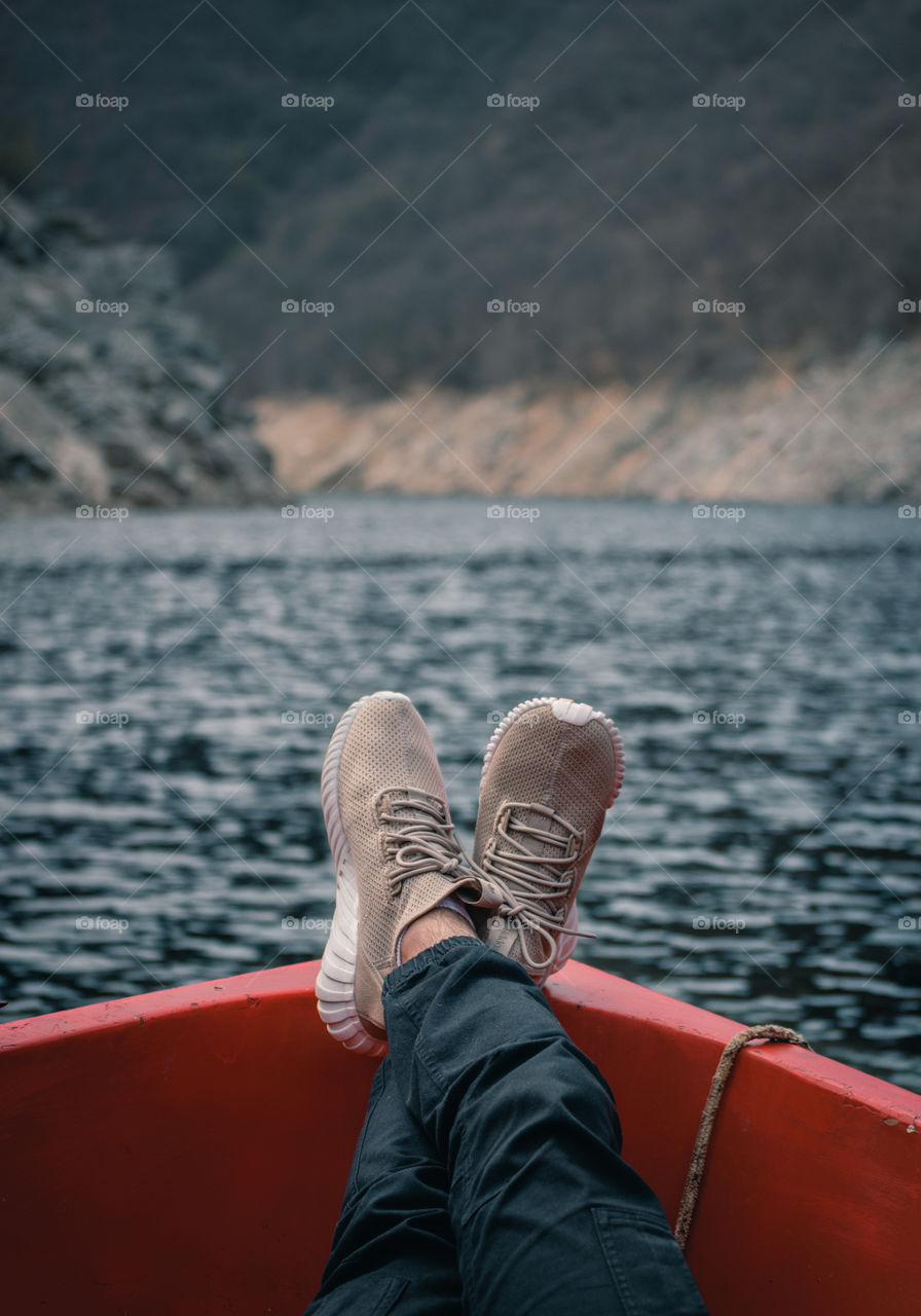 Man on a boat relaxing in a lake.