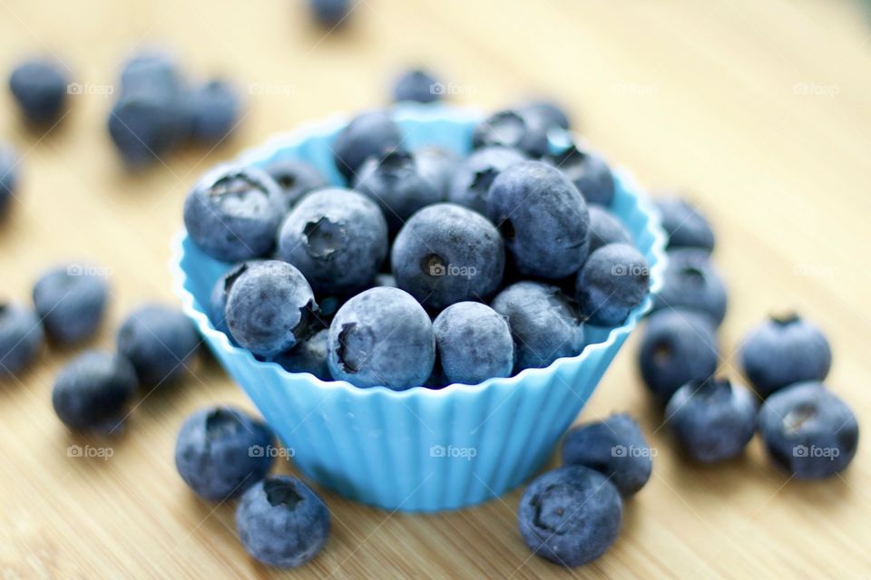 Fruits! - Blueberries In blue silicone baking cups on bamboo surface