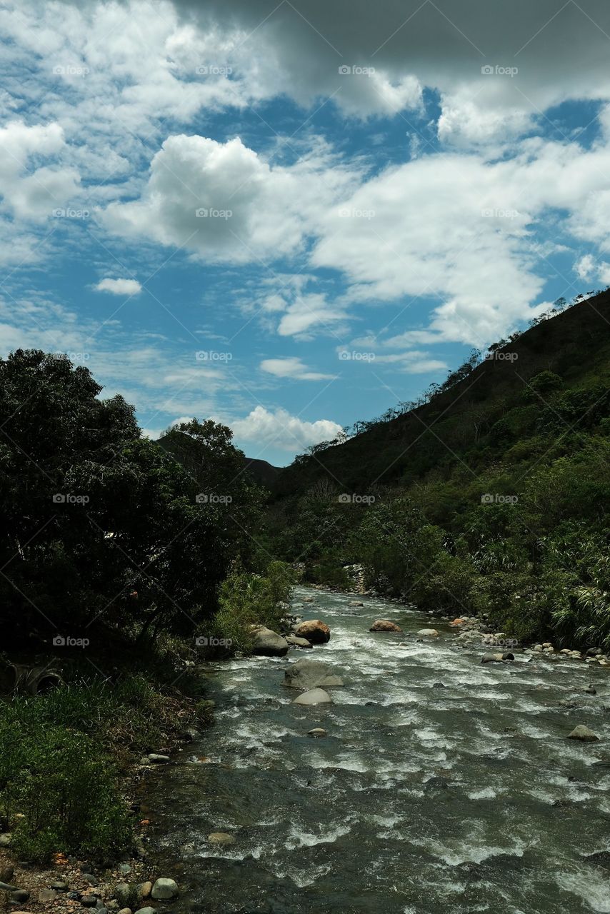 Flowing river with blue sky and clouds