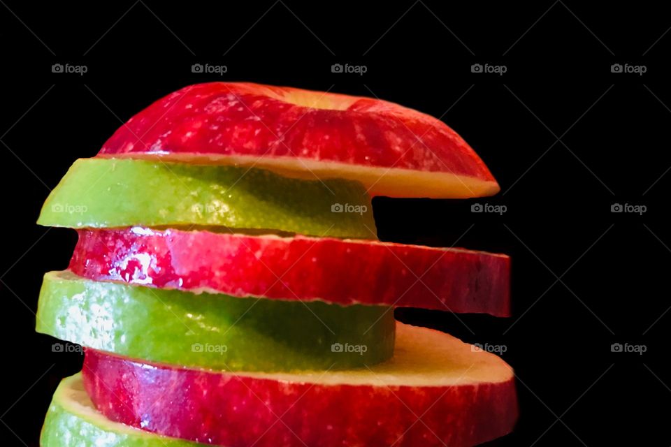Apple and lime slices against a black background