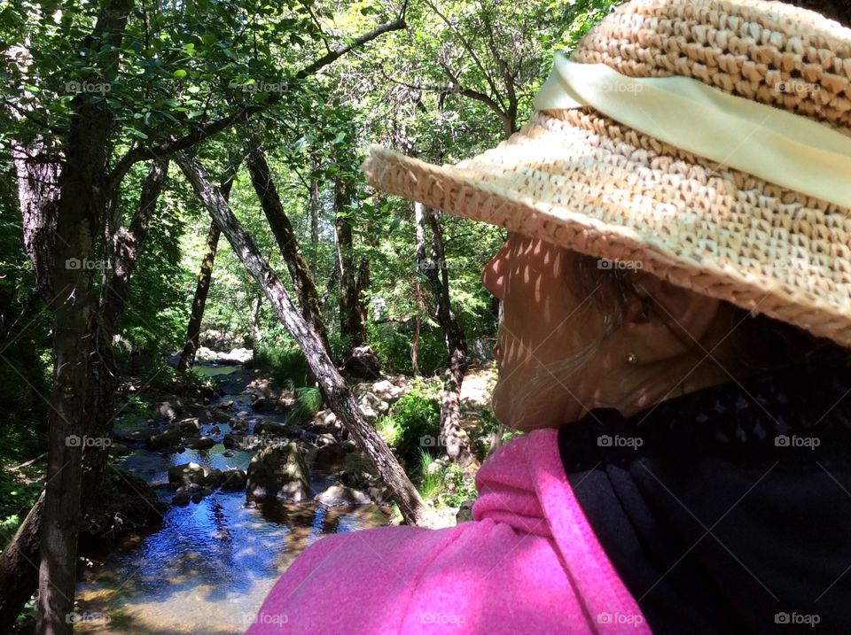 Woman viewing brook. Side profile woman on straw hat viewing brook