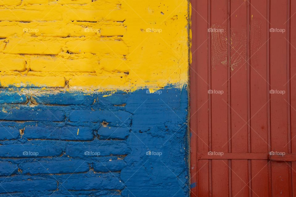 A multicolored exterior wall and door of a building in San Miguel de Mexico.