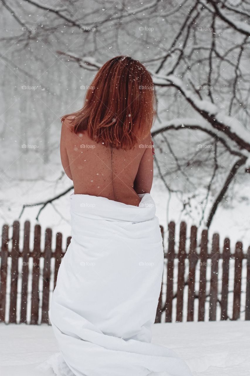 silhouette of a woman wearing a blanket in the snow