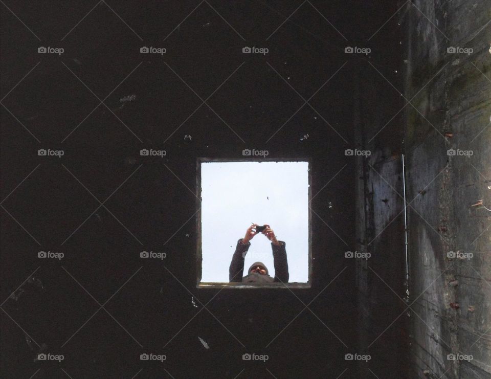 photographer's reflection in a well of water