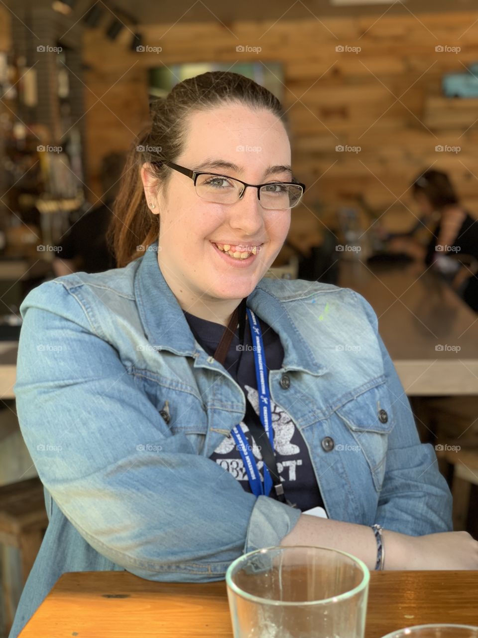 Smiling young adult in a denim jacket at a local restaurant in Omaha Nebraska