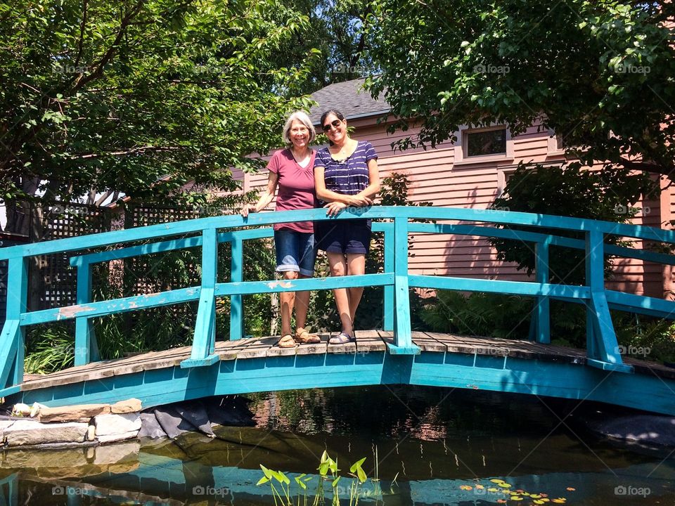 Mother and daughter on bridge in Japanese garden 