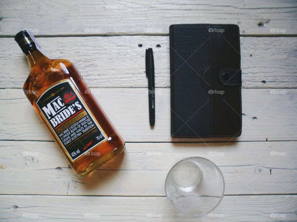 a bottle of brandy, a notebook and a glass