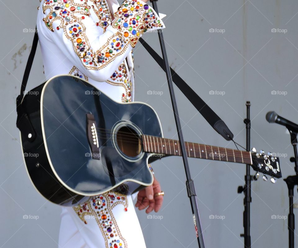 Taking care of business. Impersonator with black guitar performing