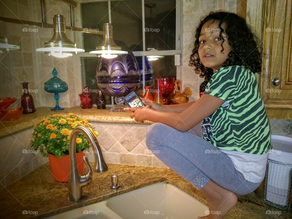 Young girl sitting near sink