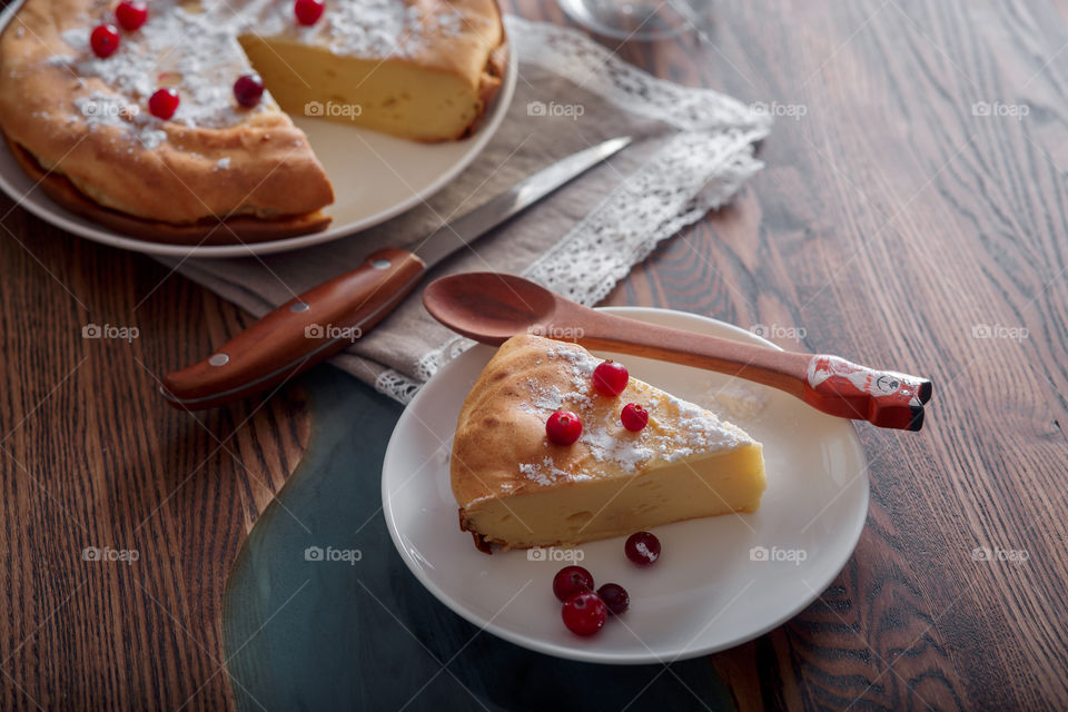 Cheesecake with cranberries and sugar on wooden background