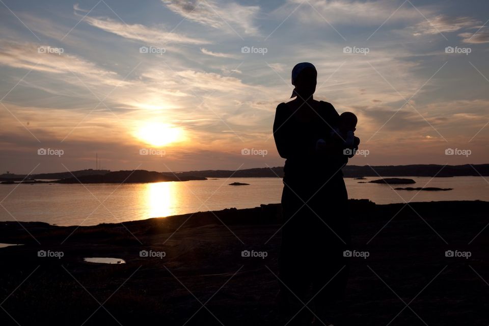 Woman with baby, sunset