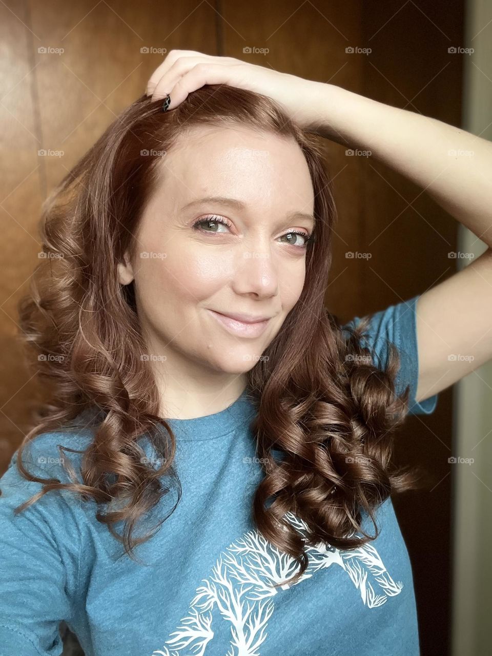 A woman with shiny brown curly hair