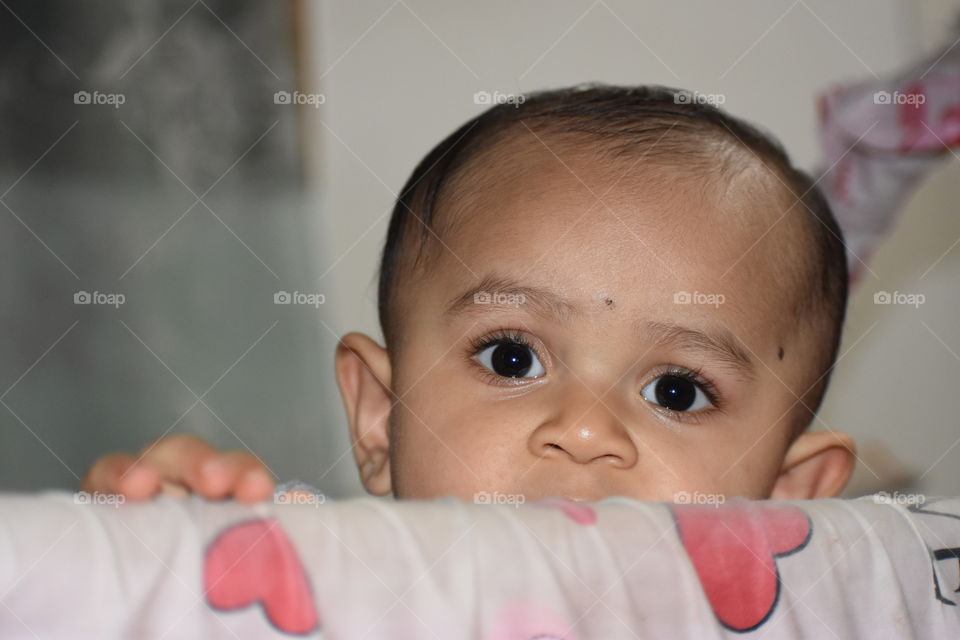 Cute baby looking out from cradle