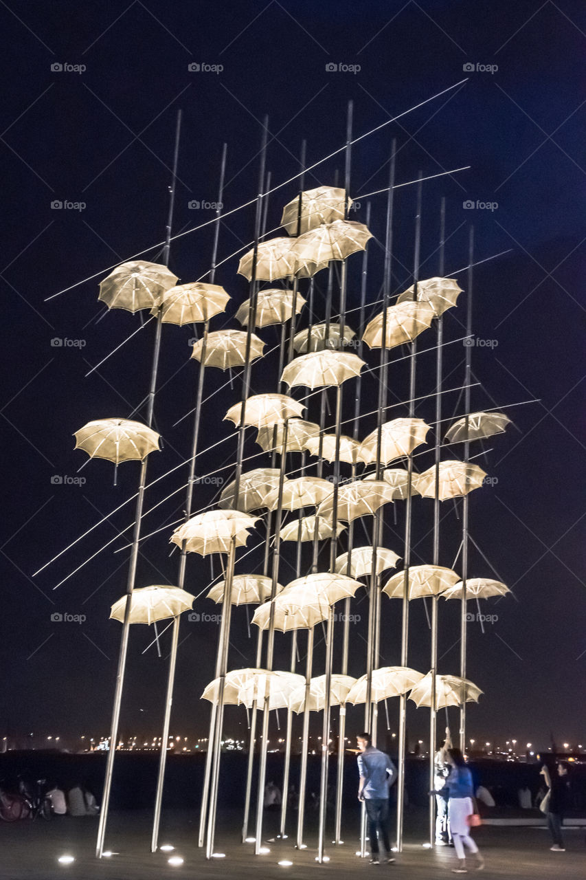 People Enjoying Night Out At Thessaloniki Famous Umbrellas Sculpture
