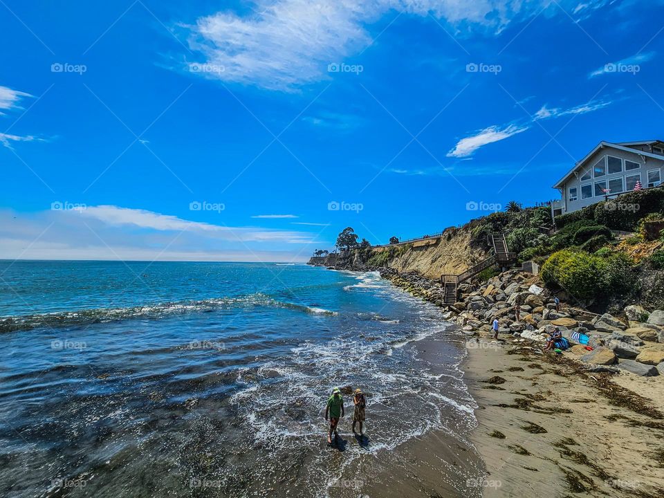 Walking on the beach in the summer in Capitola California on a clear warm day with the cool water of the Pacific Ocean 