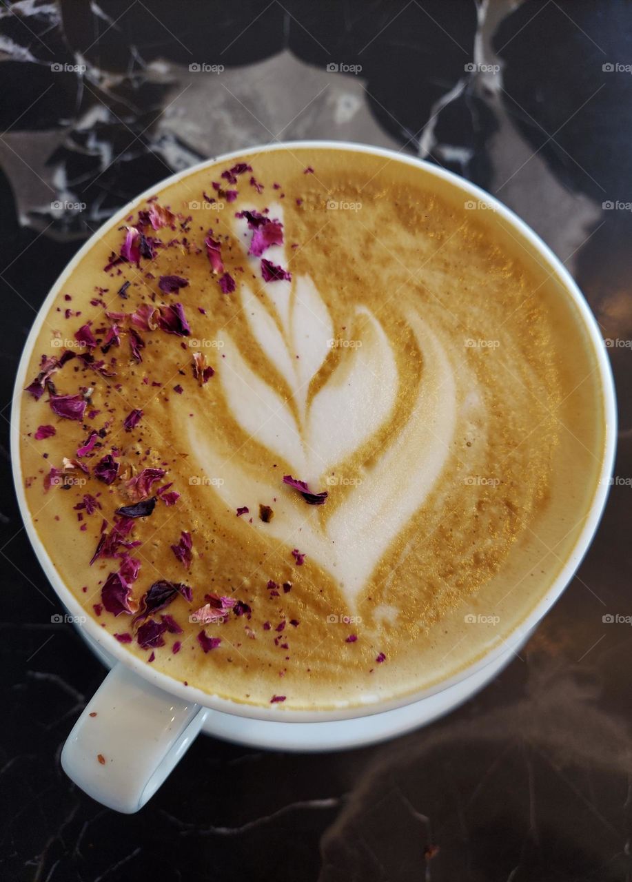 A visually satisfying latte topped with crushed rose and lavender.