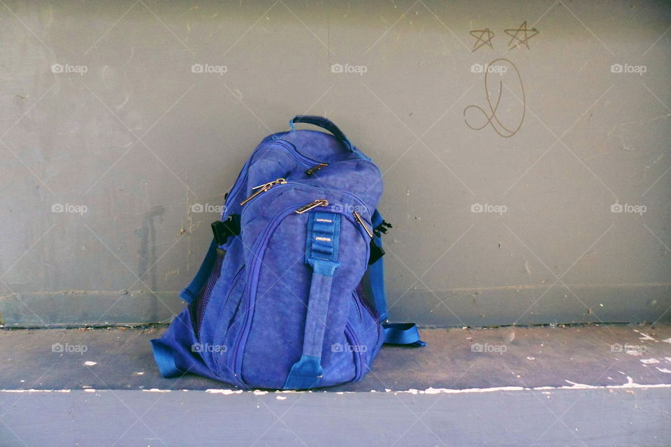 blue backpack on a gray wall background