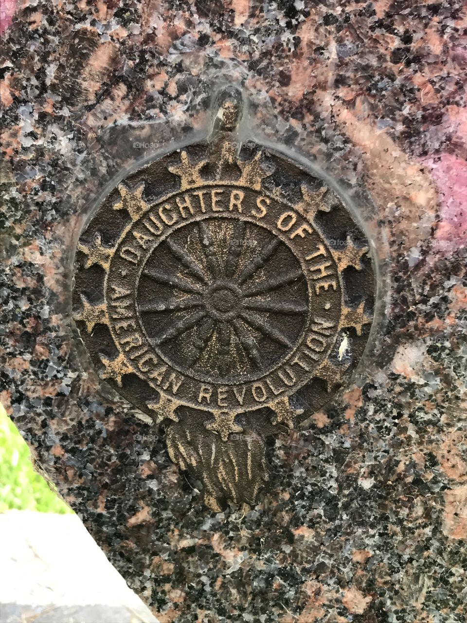 Daughters of the American revolution marker glued to a cemetery headstone