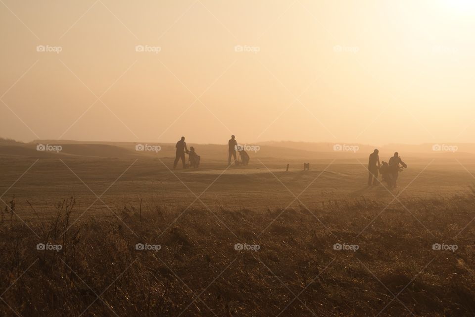 Golfers in the mist