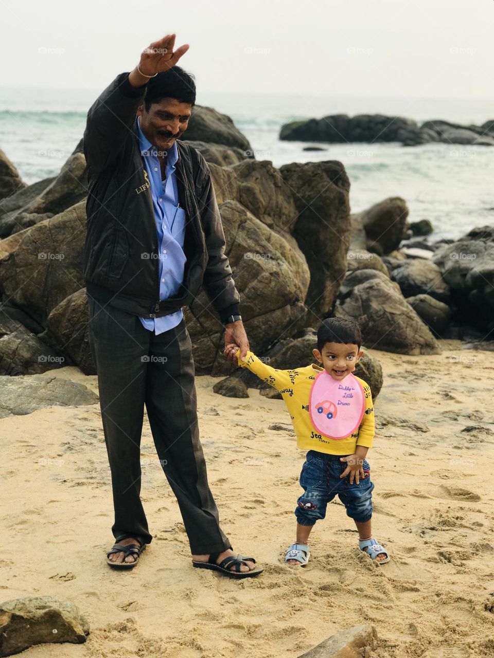 Grandfather and grandson having great fun at beach both are enjoying a lot and so happy with cheerful faces 😍