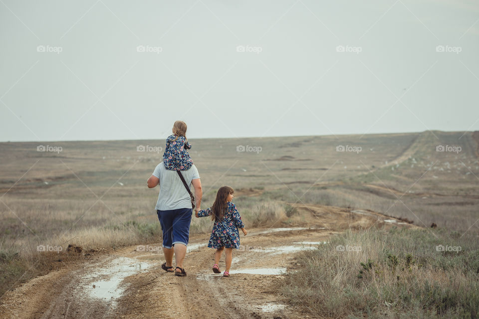 Father with two daughters walking outdoor 