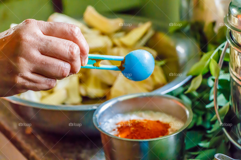 Person's hand cooking indian food