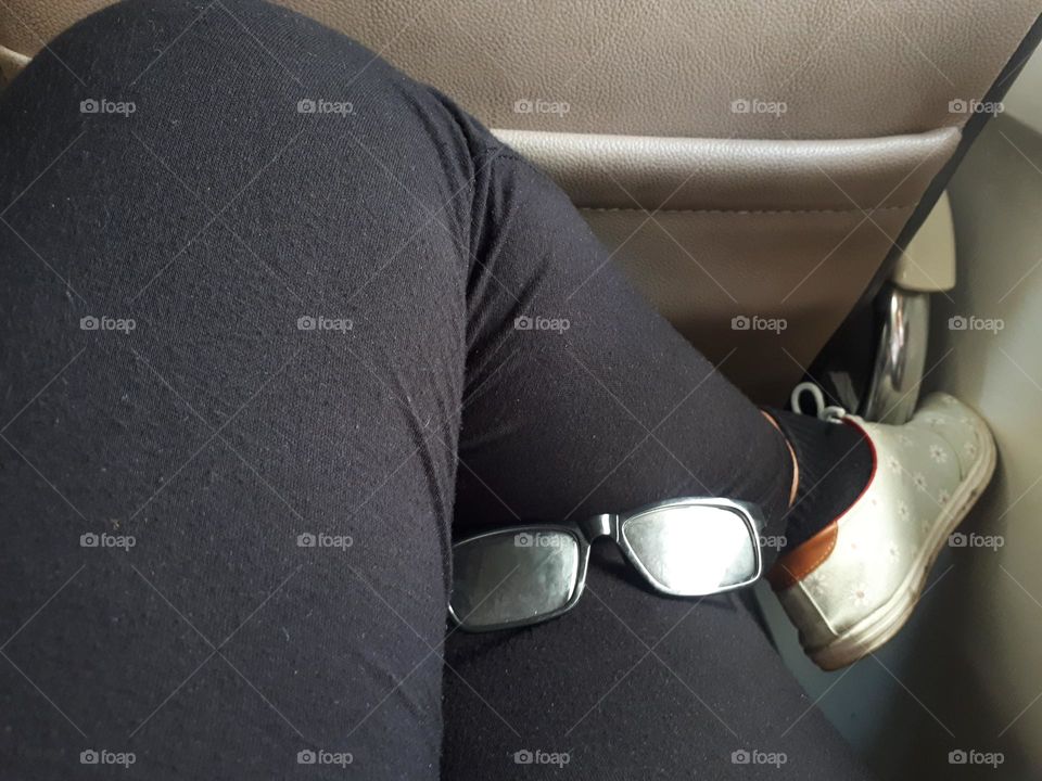 glasses as a cute accessory when placed on a woman's thigh while sitting on a train