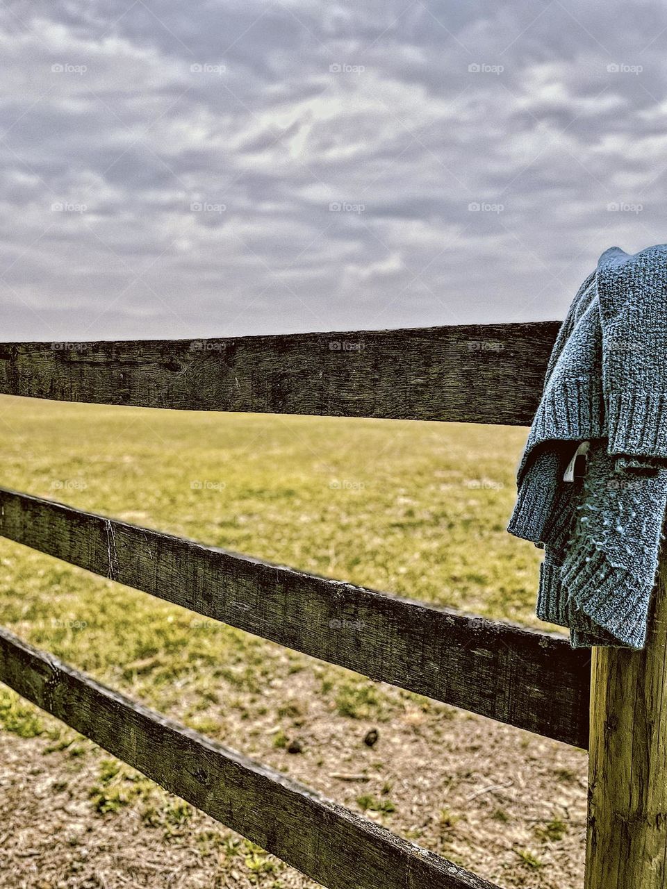 Sweater hangs on a fence post in the countryside, vacationing at a working horse farm, vacationing on the countryside, forgotten sweater in the fence, the little things in the farm