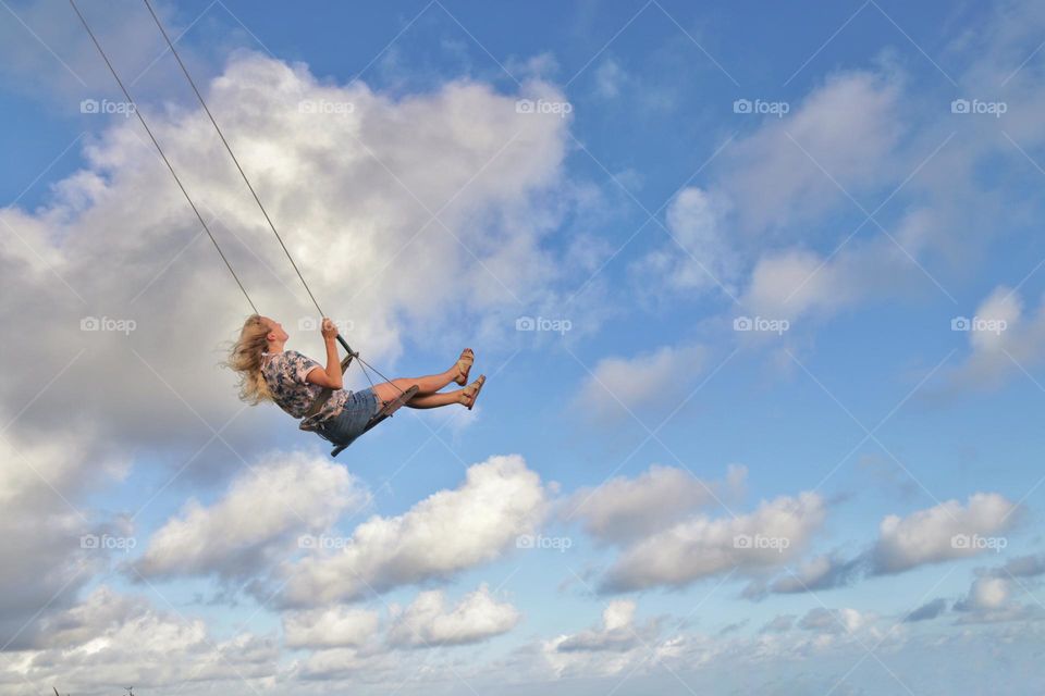 girl on a swing in the clouds