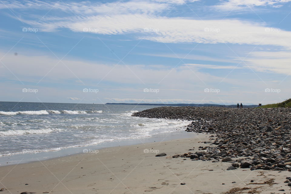 A sunny and partly cloudy day on a rocky beach in wells maine