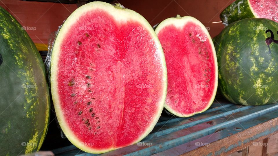 Melancias inteiras e cortadas ao meio.