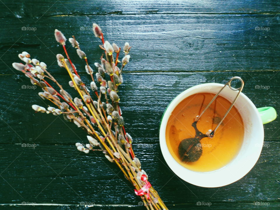 cup of tea and willow branches on a black background