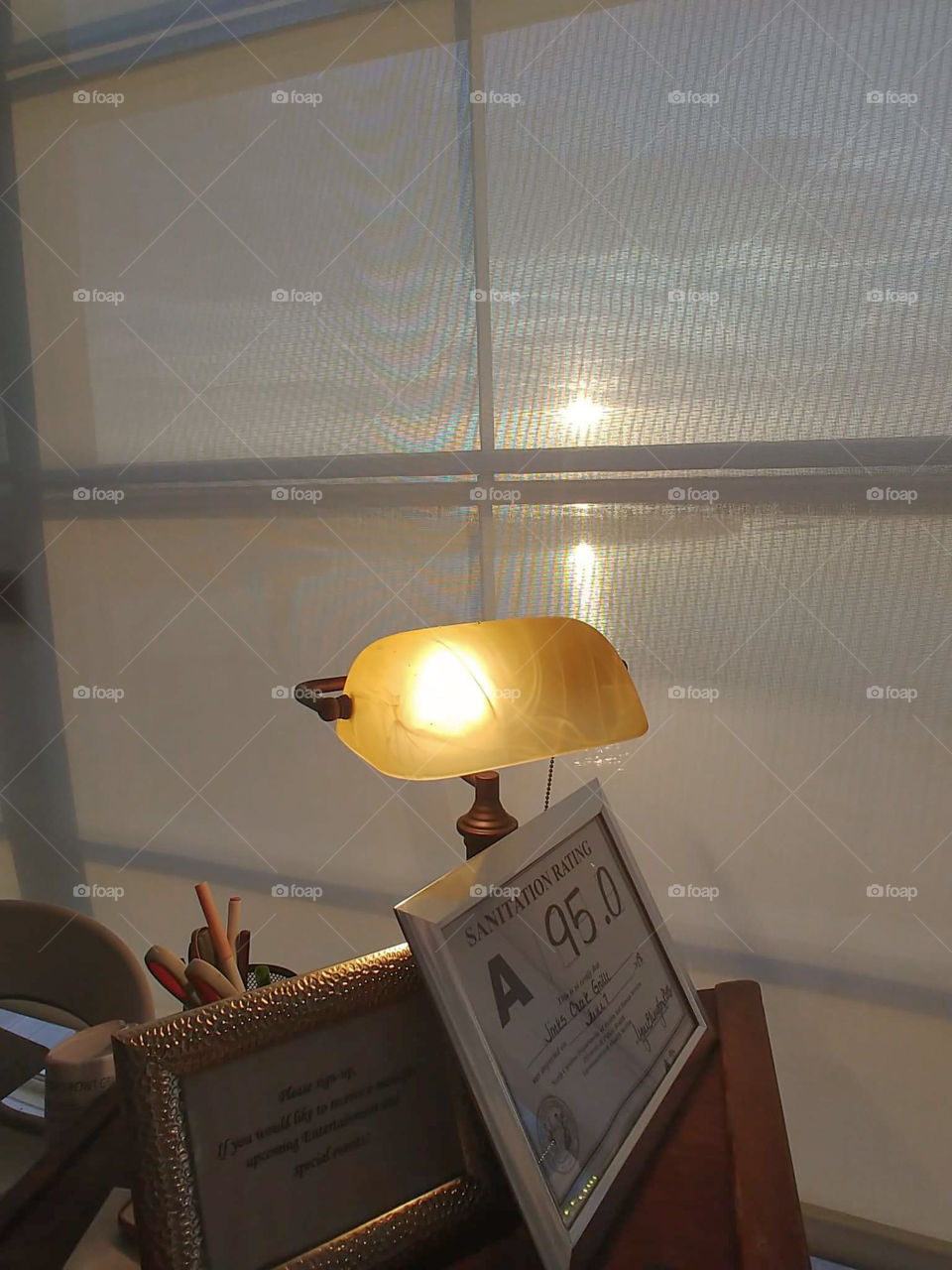 Sunset through window of restaurant located over sound, inlet, waterway. Includes lamp and sanitation grade.